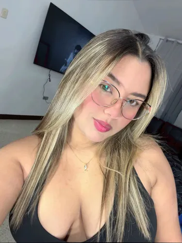 Young woman in a light top chatting on a webcam from a bright room