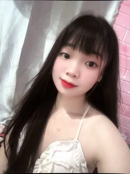Smiling young woman with long dark hair waving during a video chat