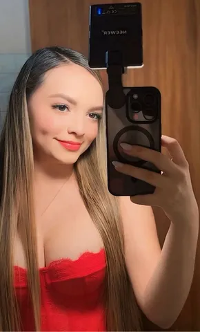 Woman smiling at her phone during a relaxed video chat at home